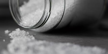 En burk salt som ligger ned på ett bord.